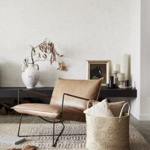 Sessel auf Teppich mit Korb davor