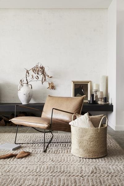 Sessel auf Teppich mit Korb davor